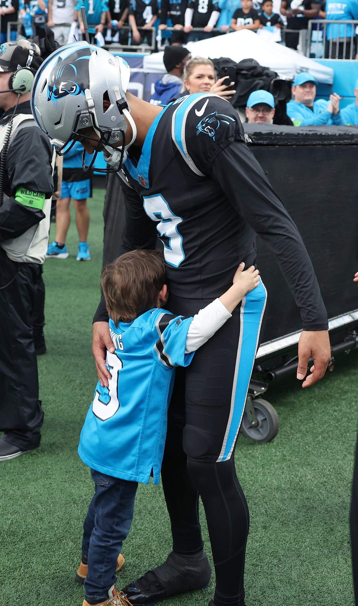 A young Carolina Panthers fan, left, gives quarterback Bryce Young, right, a hug prior to the team’s game against the Los Angeles Rams at Bank of America Stadium on Saturday, January 10, 2026. The Rams defeated the Panthers 34-31.