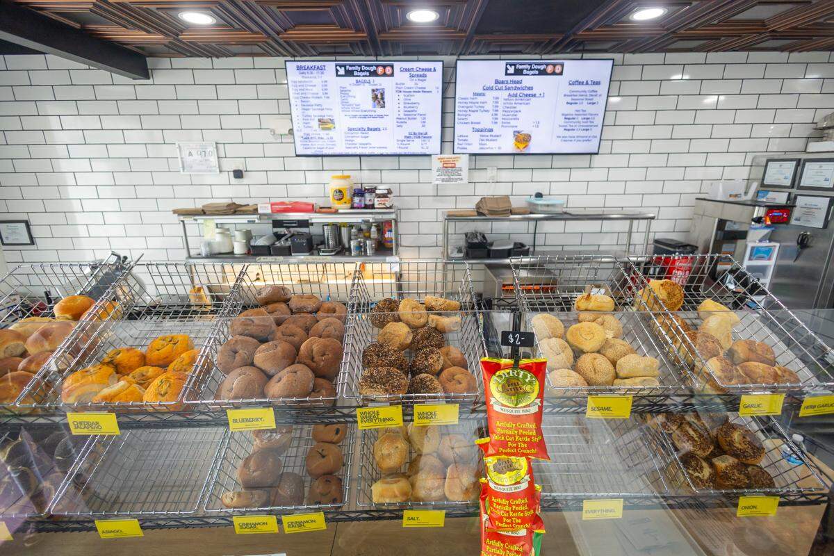 Multiple bins of bagels on display at Family Dough Bagels.