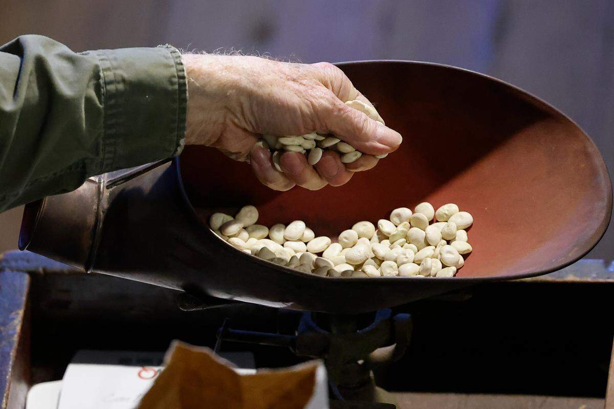 Silas Davis, of Charlotte, N.C., owner of the Davis General Store, weighs handfuls of beans to fulfill an order at the Davis General Store in Charlotte, N.C., Tuesday, April 19, 2022.
