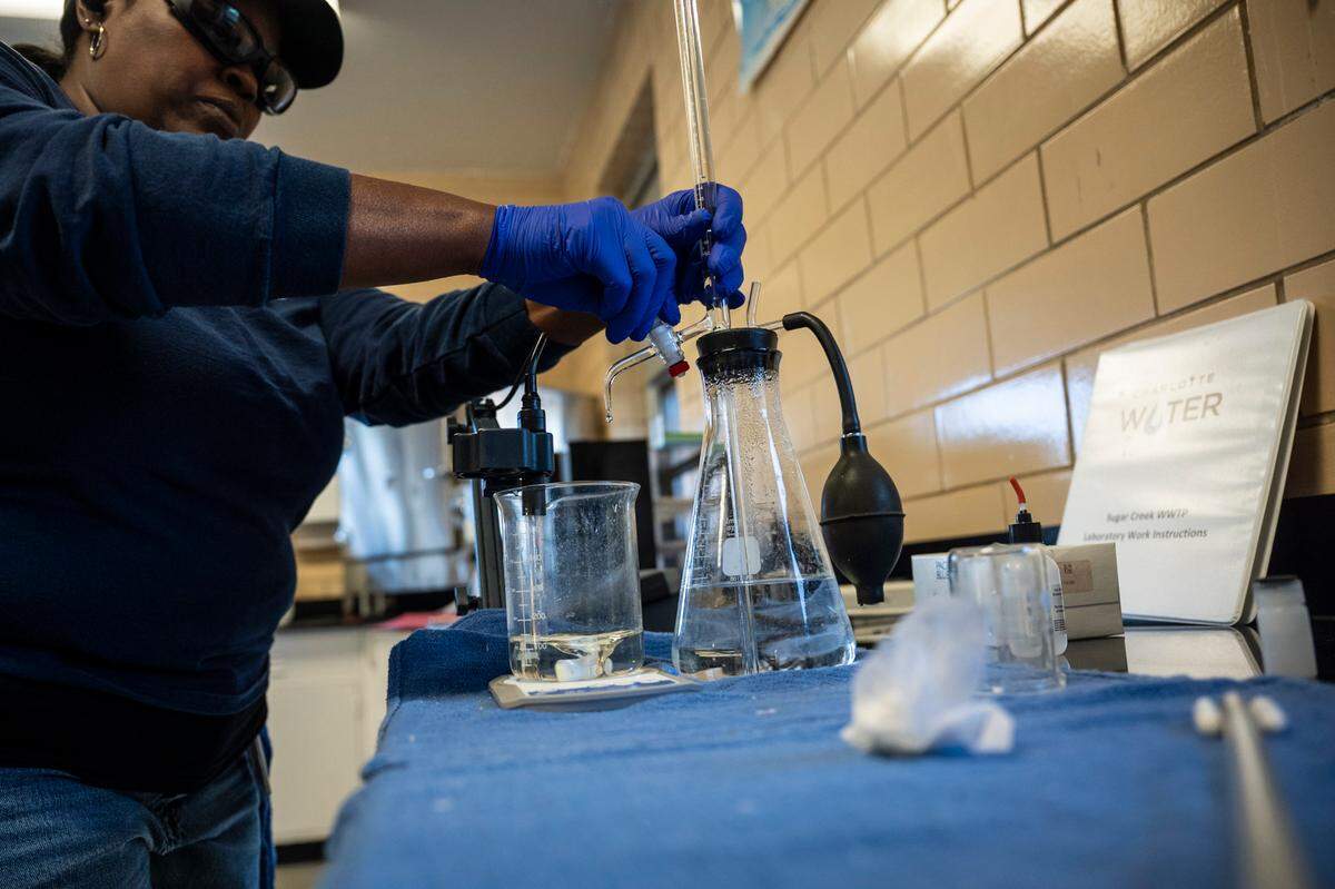 Treatment operator Stacia Wilkes runs process control tests in a lab at the Sugar Creek Wastewater Treatment Plant in October 2022. Lab techs like Wilkes take samples all day to ensure everything is flowing the way it should and that the water flowing into the creek does not contain unexpected contaminants.