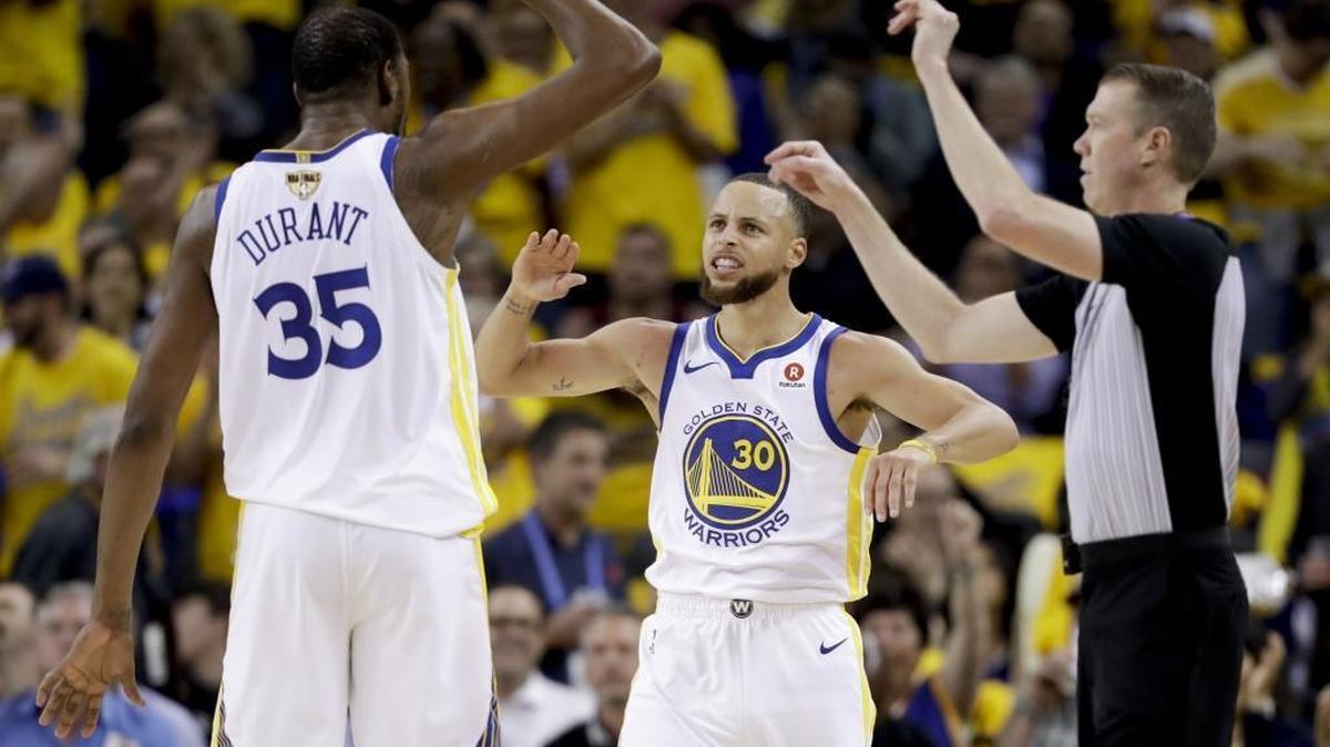 Golden State Warriors forward Kevin Durant (35) celebrates with guard Stephen Curry (30) during the second half of Game 1 of basketball's NBA Finals against the Cleveland Cavaliers in Oakland, Calif., Thursday, May 31, 2018. (AP Photo/Marcio Jose Sanchez)