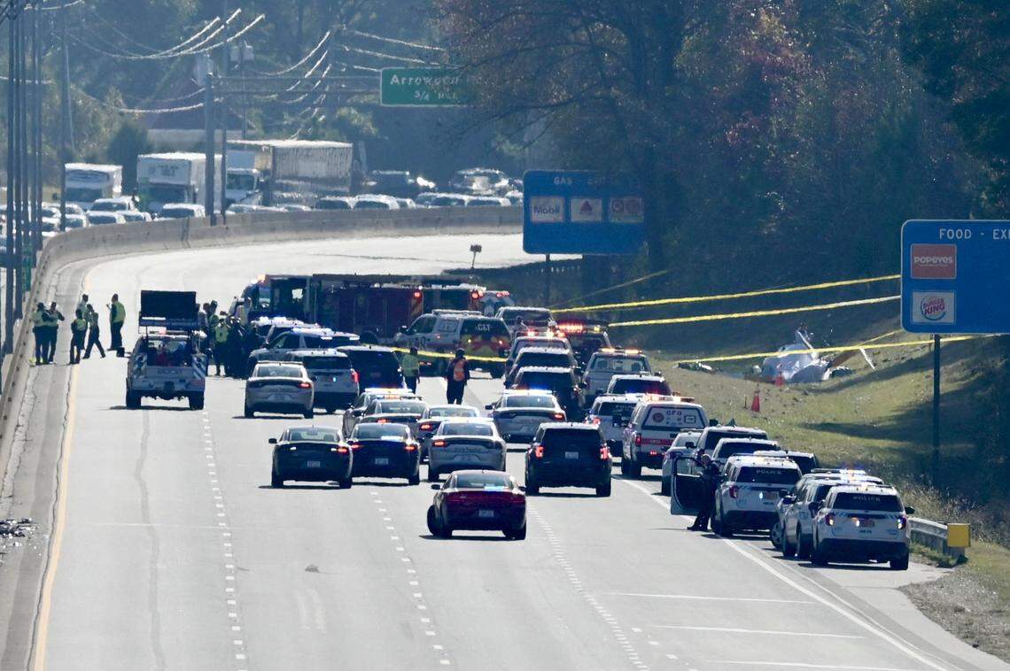 The remains of a helicopter sit to the right side of I-77 South past the Tyvola Road exit on Tuesday, November 22, 2022. Two people were confirmed dead in the crash, which involved a WBTV helicopter. 