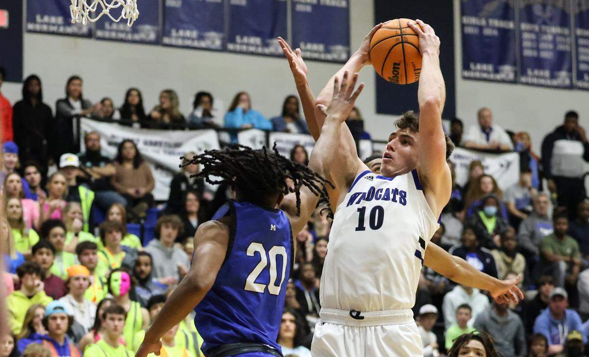 Lake Norman’s Cole Callaway, right, shoots past a block by Mooresville’s Marley Samuel at Lake Norman High School, N.C., on Tuesday, Jan. 17, 2023. 
