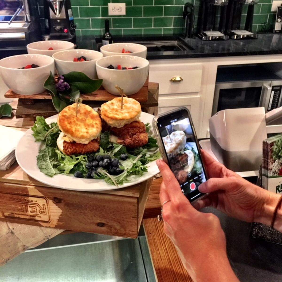 Oooh, chicken biscuits: A member of the media focuses on the breakfast game at the new Reid’s uptown.