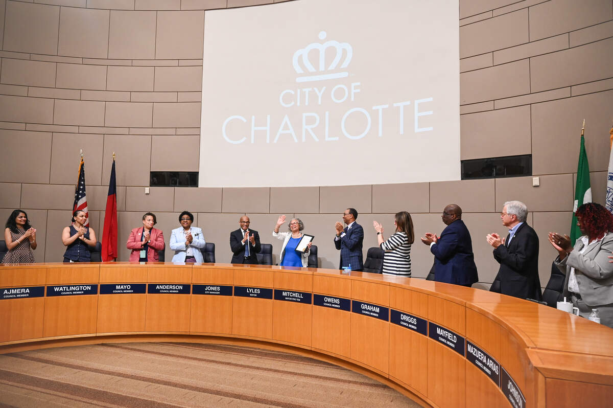 Mayor Vi Lyles, center, is honored with a standing ovation during her final city council meeting at the Charlotte-Mecklenburg Government Center.