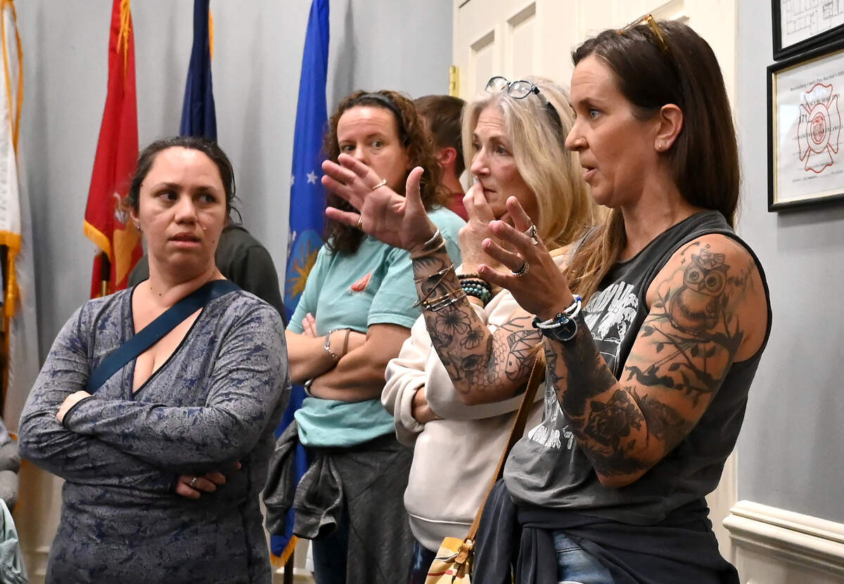 Matthews resident Lindsay Sawey, right, asks a question of Engineered Land Solutions CEO Drew Nations during a community meeting at the Matthews Town Hall on Thursday. A rezoning petition for a proposed data center is receiving opposition in Matthews.