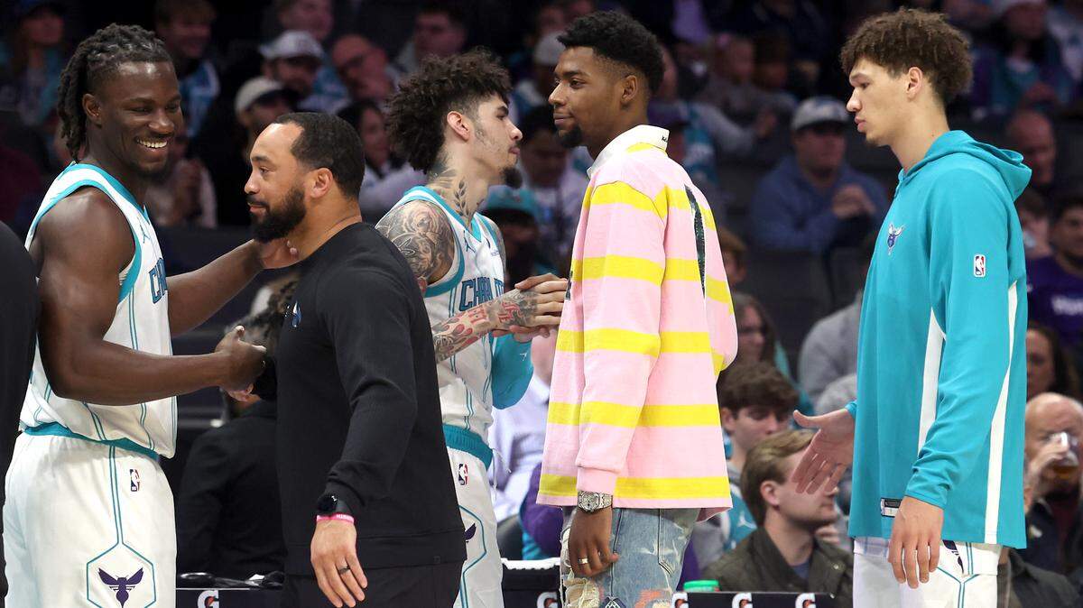 Injured Charlotte Hornets forward Brandon Miller, center, shakes hands with his teammates as they prepare to play the Orlando Magic at Spectrum Center in Charlotte, NC on Thursday, October 30, 2025. The Magic defeated the Hornets 123-107.