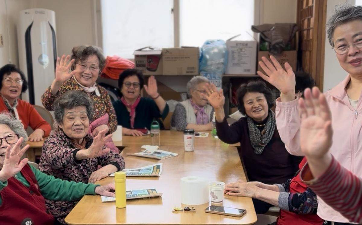 Senior residents at the Dongnimmun Parkville apartments in Seoul wave goodbye to Théoden Janes after he shared his story with them during a recent visit with his family.