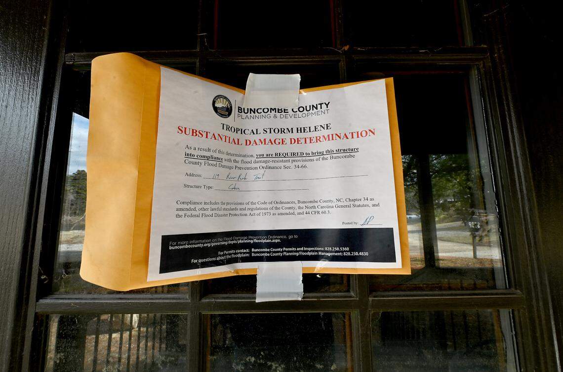 A notice detailing damage from Hurricane Helene is attached to the front door of a cabin at Asheville River Cabins in February.
