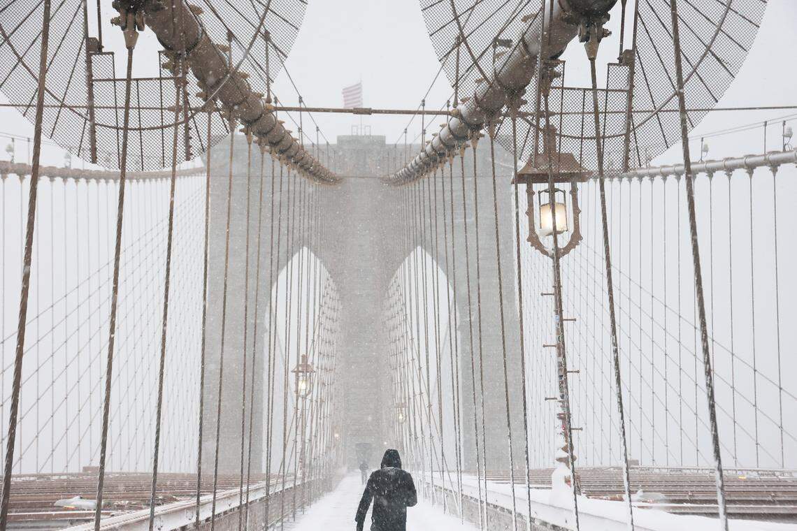 NEW YORK, NEW YORK - FEBRUARY 23: People walk along the Brooklyn Bridge during a blizzard on February 23, 2026 in New York City. The northeast U.S. is bracing for an intense nor'easter with blizzard conditions, heavy snow, and strong winds. New York City Mayor Zohran Mamdani announced a state of emergency for NYC and issued a travel ban beginning at 9 p.m. tonight, and ending at 12 p.m. on Monday. NYC could get more than a foot of snow with up to two feet on Long Island and in parts of New Jersey. (Photo by Michael M. Santiago/Getty Images)