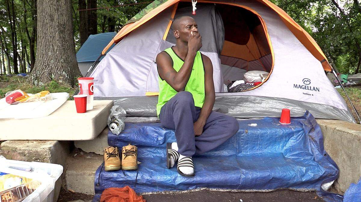 Anthony Martin sits outside his tent in a lot along Poplar and 12th Streets in Charlotte, NC on Wednesday, August 12, 2020. Martin along with other homeless people received a notice informing them that they were trespassing on private property and have until Friday, August 14, 2020 to vacate the property.