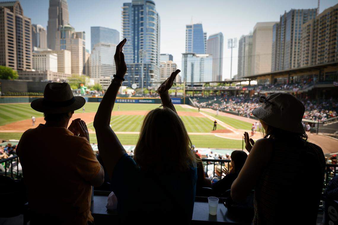 Todd Wiedman, left, Stacy Wiedman, and Stephanie Wiedman, all of Charlotte, celebrate a run scored by the Charlotte Knights during a game against the Memphis Redbirds.