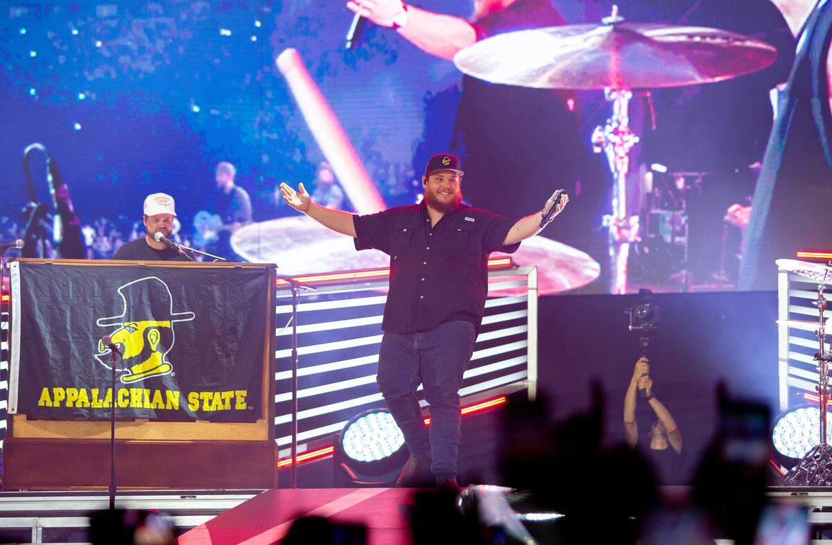 Panthers superfan Luke Combs smiles as he takes the stage at Bank of America Stadium in July 2023, when Combs played two nights in Charlotte to a packed stadium. Combs wasn’t high on the Panthers’ impending trade of Brian Burns, which was reported Monday.