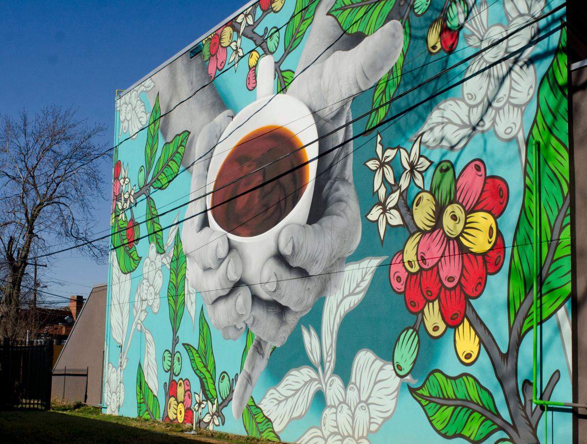 The East Charlotte mural behind The Giddy Goat Coffee Roasters is painted by Darion Fleming