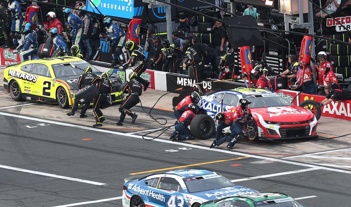 NASCAR Cup Series driver William Byron’s pit crew, right, hurry to change tires and fuel the car during the Coca-Cola 600 on May 25, 2025, at Charlotte Motor Speedway.