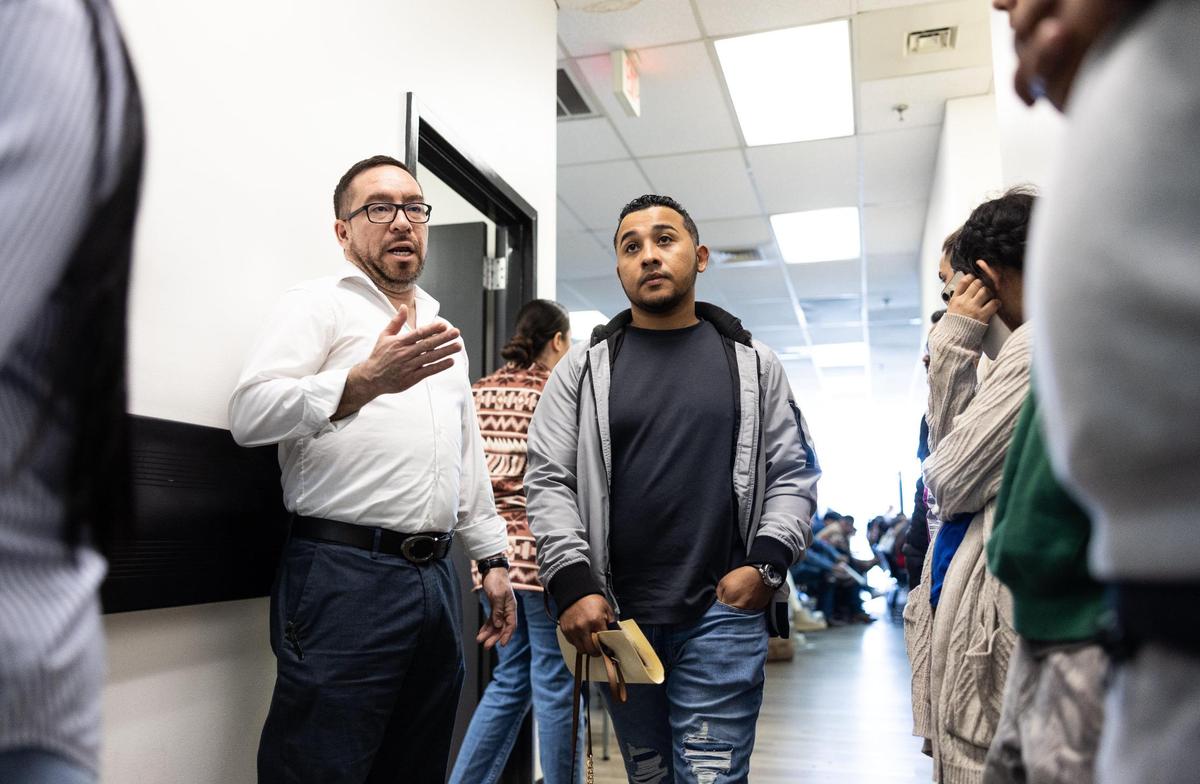 Consul General Enrique Flores Dubon, left, speaks to people waiting in line at the Honduran Consulate in Charlotte on Friday. He says more Hondurans are trying to get their kids citizenship in Honduras after President Trump returned to office and that more are returning home.