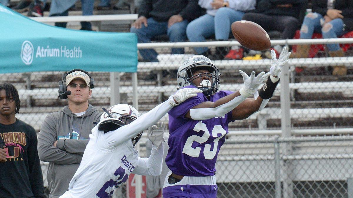 Daniel Haughton #23, of Charlotte Latin and the East squad, pulls in a long pass while the West’s Ryan Teeter, #20, of Mallard Creek, defends in the first quarter of the Queen City Senior Bowl. The West squad took a 27-3 lead into halftime at the Queen City Senior Bowl. Split between East and West teams about 80 high school football stars from almost 60 schools across the Charlotte region squared off in the Queen City Senior Bowl on Saturday, Dec. 18, 2021 at Olympic High School.