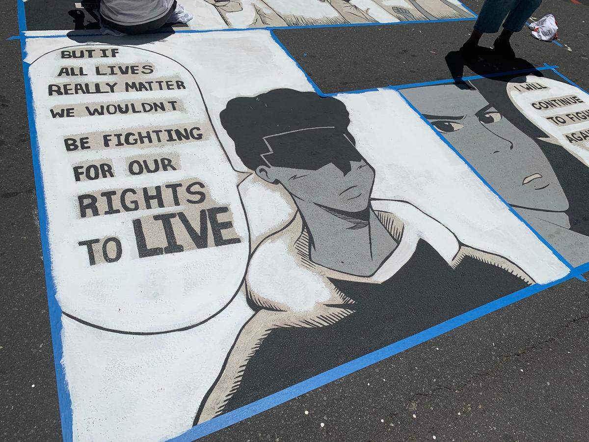 The “E” on the Black Lives Matter mural in uptown Charlotte on Tryon Street, painted and under repair by artist Kiana Mui.