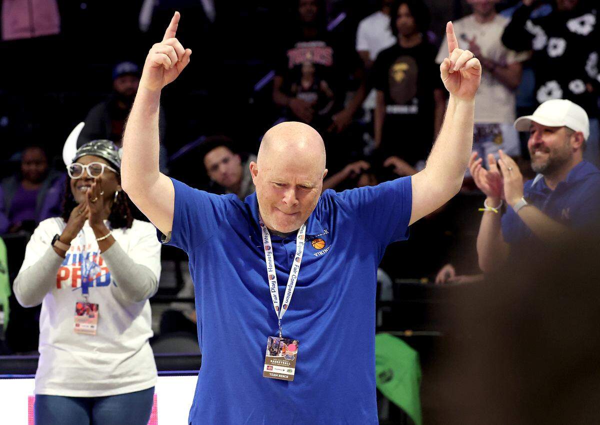North Meck Vikings head coach Duane Lewis raises his arms to the cheers of fans following the teams 59-56 victory over New Hanover in the boys NCHSAA 4A State Championship game at Lawrence Joel Veterans Coliseum in Winston-Salem, NC on Saturday, March 15, 2025.
