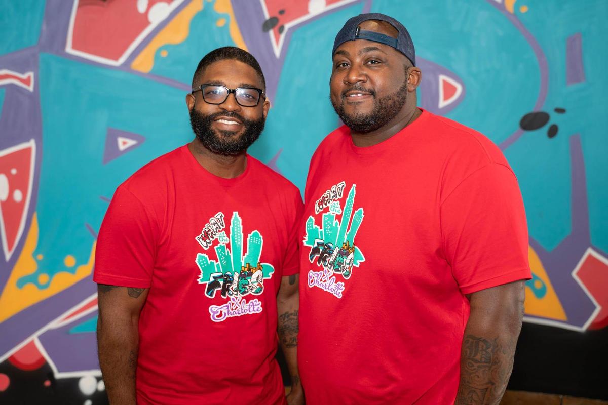 What The Fries owners Jamie Barnes and Greg Williams in front of art by Swych19 inside their new restaurant in Pineville.