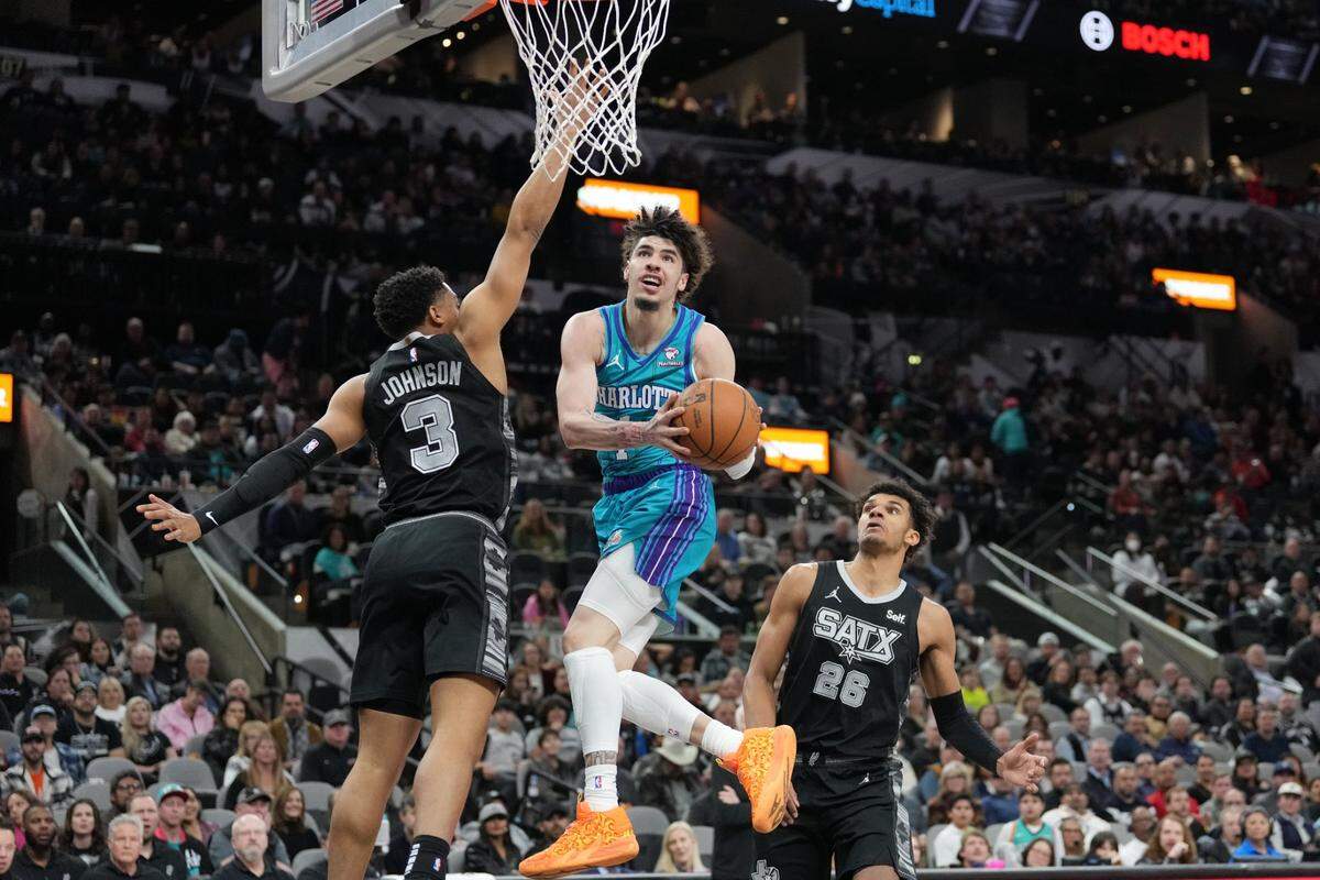 Charlotte Hornets guard LaMelo Ball (1) goes up against San Antonio Spurs forward Keldon Johnson (3) in the first half at Frost Bank Center.