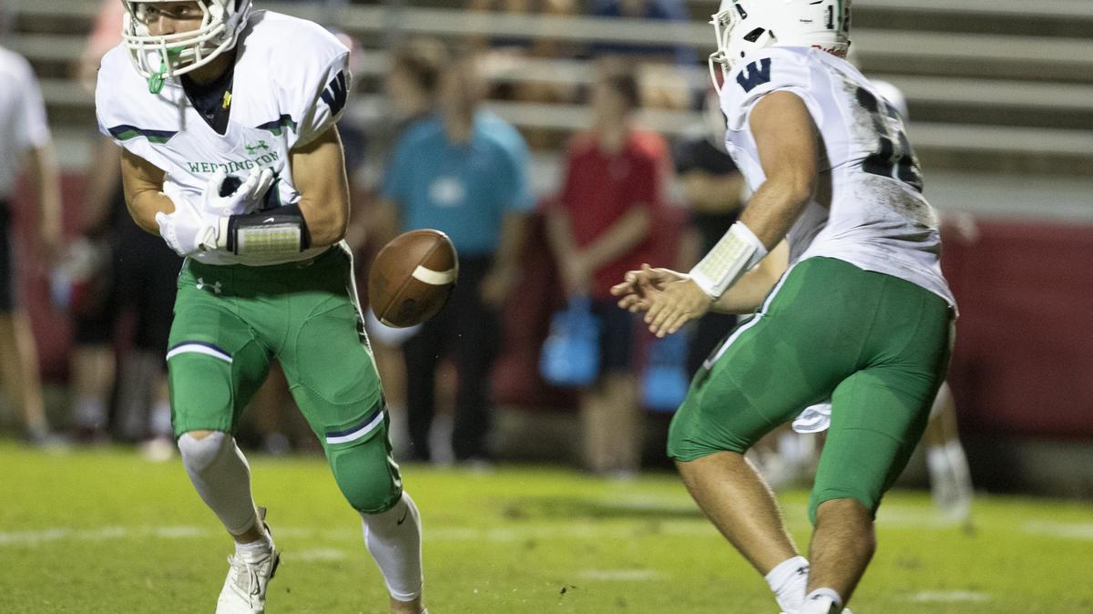 Weddington quarterback Whitner Litton (right) tries to hand the ball to Landyn Backey, but fumbles causing Charlotte Catholic to pick up the ball and score during a prep football game at Charlotte Catholic High School Friday, September 28, 2018 in Charlotte, NC. Photo by JASON E. MICZEK - Special to the Observer