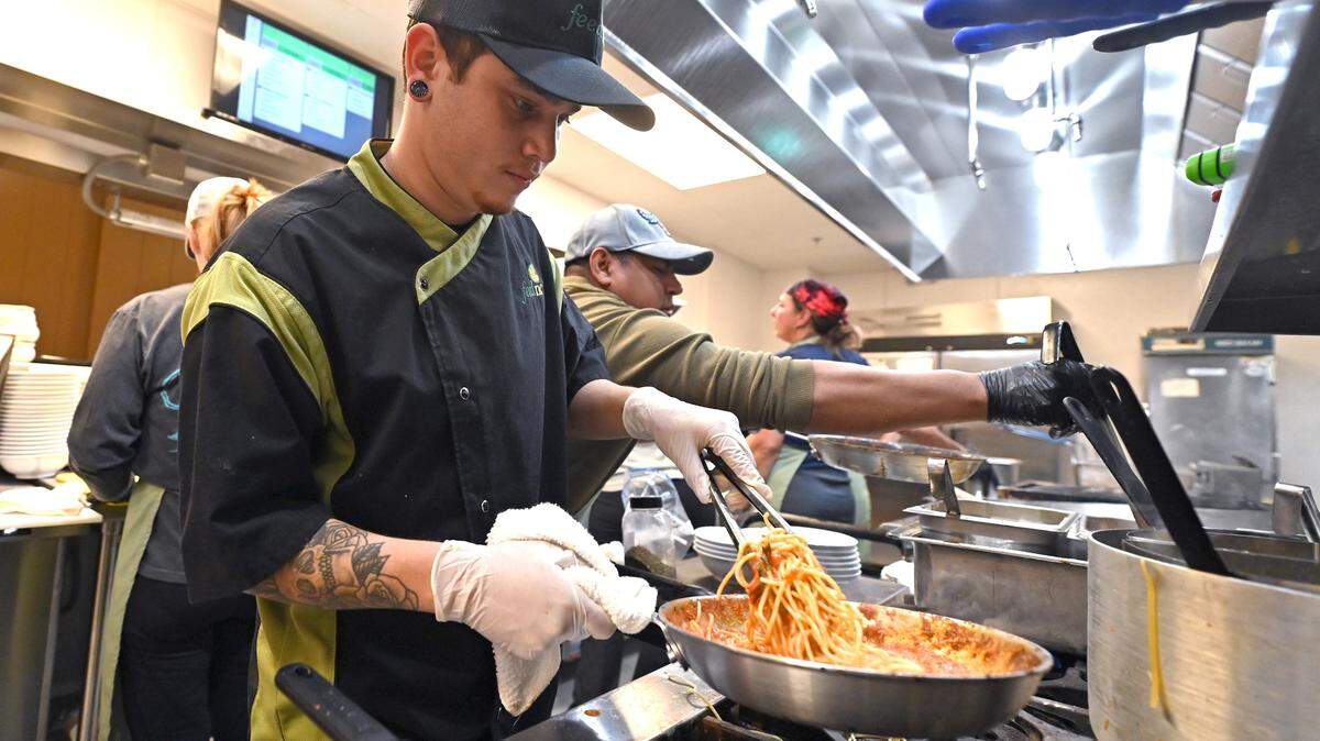 Bryan Diaz prepares lunch for a client at FeedNC on Tuesday, October 24, 2023. Diaz is part of the workforce development program at FeedNC. FeedNC formerly known the Mooresville Soup Kitchen provides breakfast, lunch and groceries to people in need each week day.