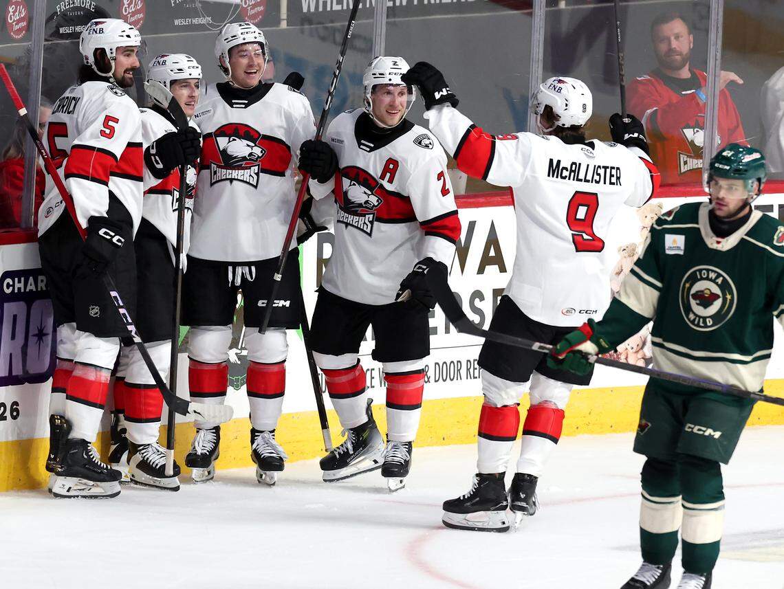 Members of the Charlotte Checkers come together to congratulate forward Ben Steeves, second from left, following Steeves’ goal during third period action against the Iowa Wild on Friday, October 17, 2025 at Bojangles Coliseum in Charlotte, NC. 