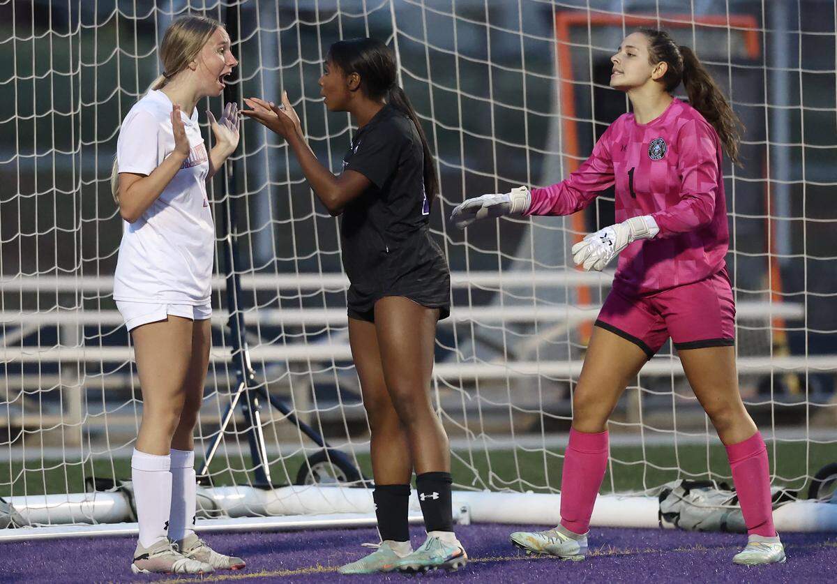 Ballantyne Ridge’s Alayna Holgorsen, left, and Ardrey Kell’s Kelley Tarpley, center, discuss play as Ballantyne Ridge goalie Bella Frankel approaches on Tuesday, April 28, 2026. Ardrey Kell defeated Ballantyne Ridge 1-0.