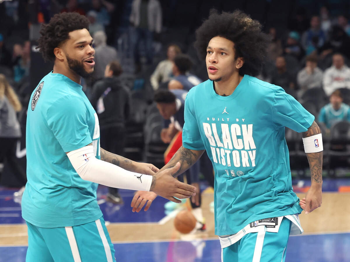 Charlotte Hornets forward Miles Bridges, left and guard Tre Mann slap hands while warming up prior to action against the New Orleans Pelicans at Spectrum Center in Charlotte, North Carolina, on Feb. 2, 2026.