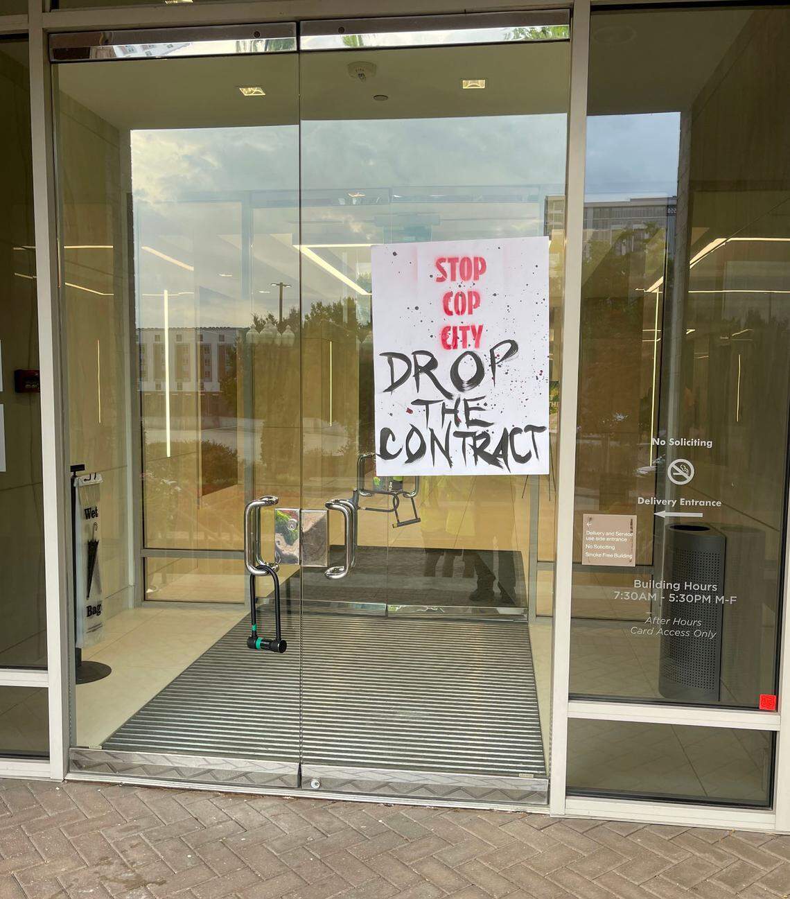Protesters on Friday left a poster that reads “Stop Cop City. Drop the Contract” on the doors of an office buliding in Charlotte Climate activists want construction company Brasfield & Gorrie to end its contract which Atlanta for a police training facility in a forest home to an indigenous tribe.
