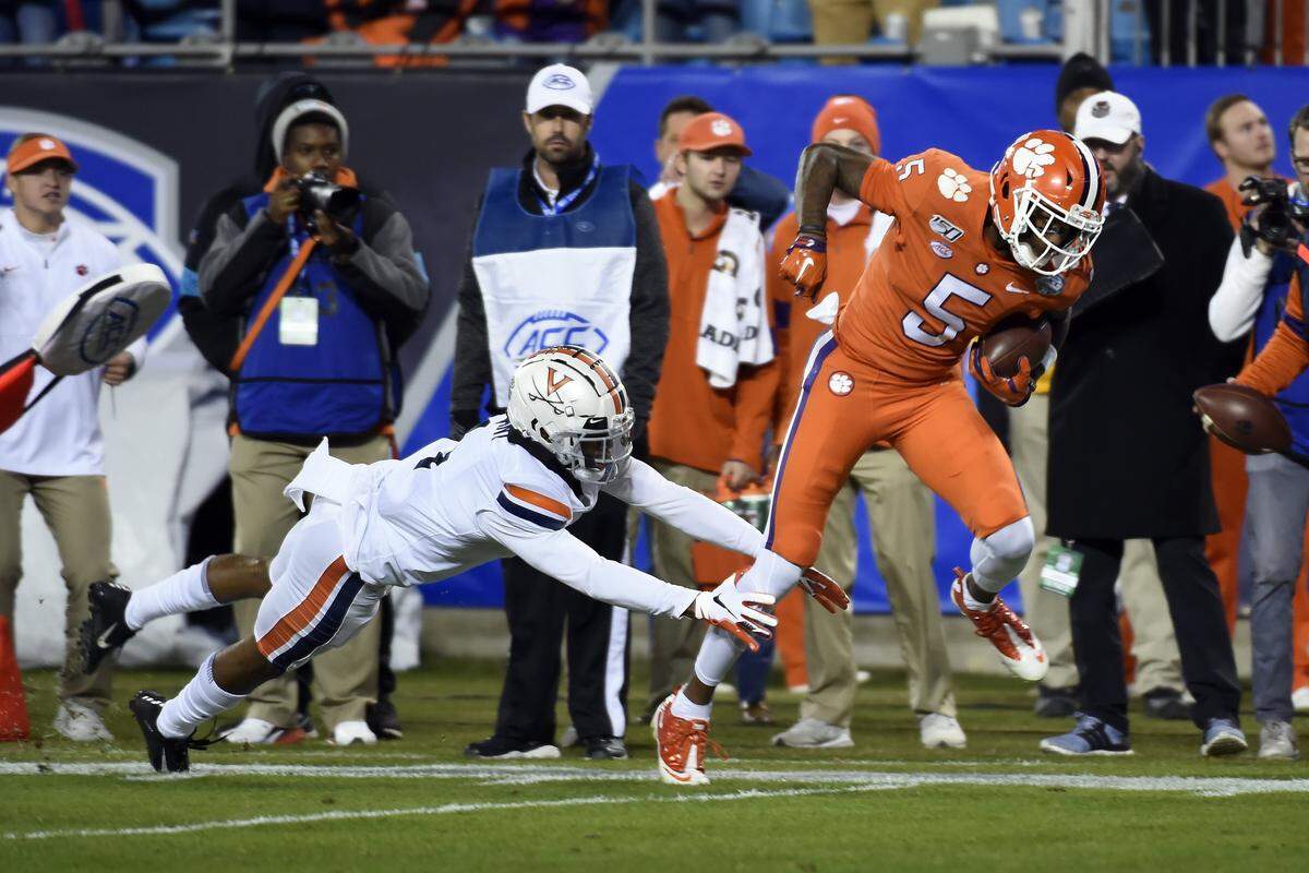 Clemson wide receiver Tee Higgins (5) breaks a tackle attempt by Virginia cornerback Nick Grant during the first half of the Atlantic Coast Conference championship NCAA college football game in Charlotte, N.C., Saturday, Dec. 7, 2019. Higgins scored on the play. (AP Photo/Mike McCarn)