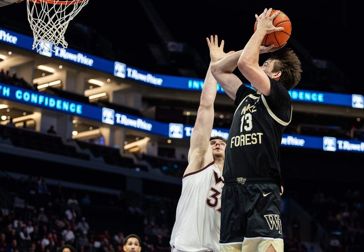 Wake Forest Demon Deacons forward Cooper Schwieger, right, shoots past a block by Virginia Tech Hokies center Christian Gurdak during the ACC men's basketball tournament in Charlotte, N.C., on Tuesday, March 10, 2026.