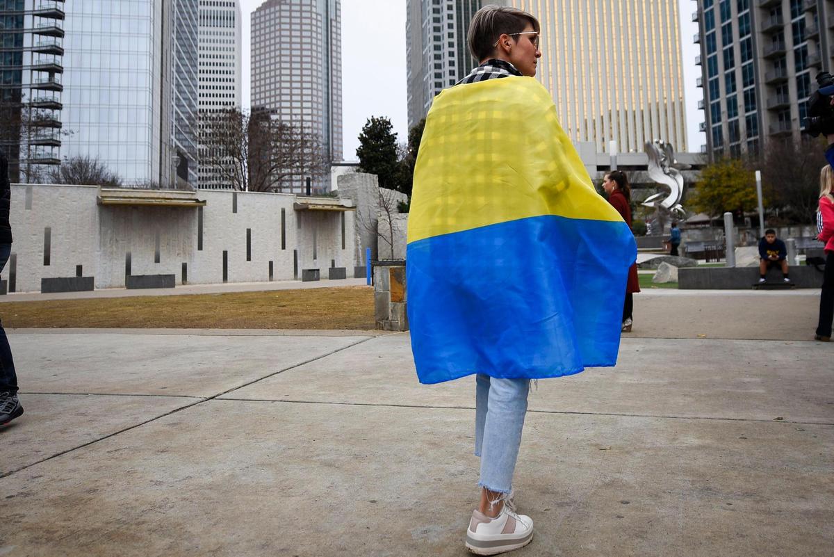 Iryna Amiramova, of Charlotte, N.C. walks through Romare Bearden Park wrapped in a Ukrainian flag during a gathering to show support for Ukraine, Thursday, Feb. 24, 2022. Amiramova moved to the United States from Ukraine about 10 years ago while most of her family and friends have remained in their home country.