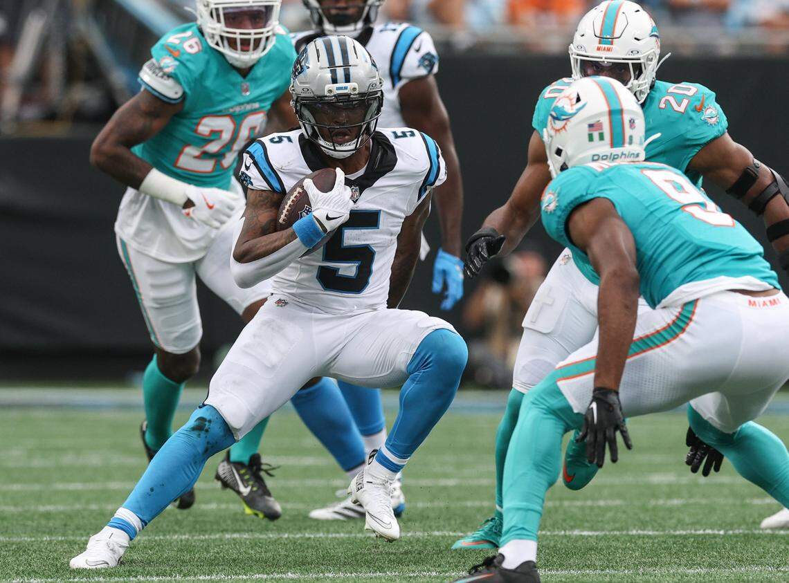 Panthers runningback Rico Dowdle, left, jukes Dolphins safety Ifeatu Melifonwu as he runs the ball during the game at Bank of America Stadium in Charlotte, NC on Sunday, October 5, 2025