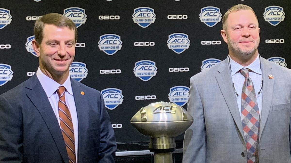 Clemson football coach Dabo Swinney (left) and Virginia coach Bronco Mendenhall pose Friday with the trophy given to the winner of the ACC football championship game prior to their teams meeting on Saturday in Charlotte.