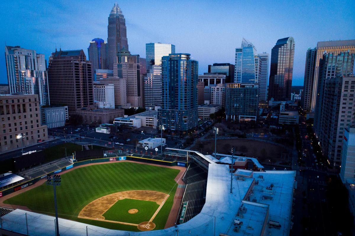 Truist Field, home to the Charlotte Knights sits illuminated against the city skyline in Charlotte, N.C., Monday, March 28, 2022.