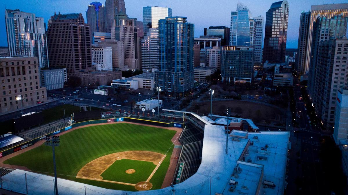 Truist Field, home to the Charlotte Knights, sits illuminated against the city skyline.