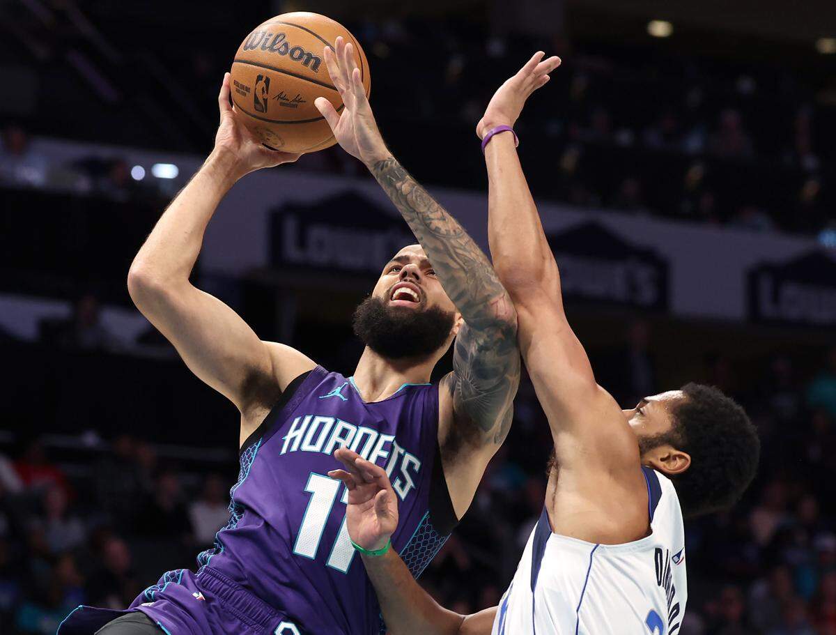 Charlotte Hornets guard Cody Martin, left, drives to the basket for a shot against Dallas Mavericks guard Spencer Dinwiddie, right, during action at Spectrum Center in Charlotte, NC on Monday, January 20, 2025.
