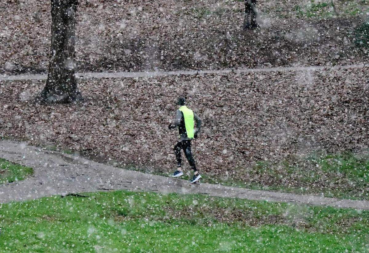A jogger runs a path in Park Road Park during a snowfall in Charlotte, NC in February, 2020. Crews intend to partially drain and dredge the pond in the park to remove sediment, trash and debris.