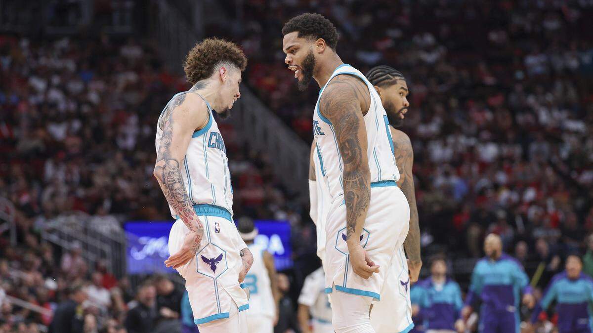 Charlotte Hornets forward Miles Bridges (0) celebrates with guard LaMelo Ball (1) after scoring a basket during the fourth quarter against the Houston Rockets at Toyota Center.