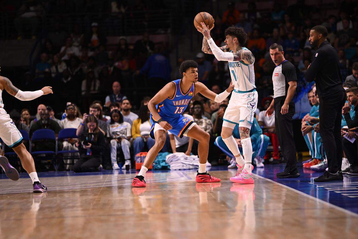 Charlotte Hornets guard LaMelo Ball (1) passes from the key against Oklahoma City Thunder forward Ousmane Dieng (13) in the first quarter at North Charleston Coliseum. 