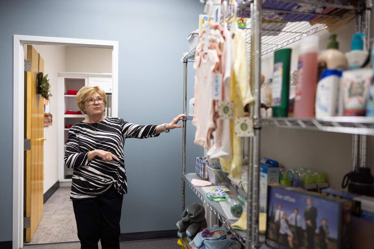 Executive Director Linda Morris points to shelves of donations for pregnant teenagers at Bridge of Hearts in Mooresville, N.C., on Tuesday, December 9, 2025. The organization annually provides birthday gifts and health and hygiene kits to about 1,000 unhoused and impoverished children, and nursery items to pregnant teens.