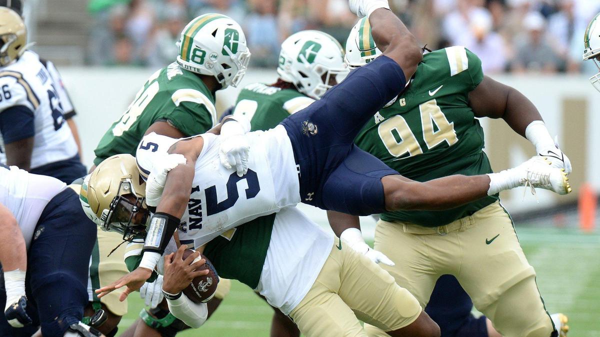Navy quarterback Braxton Woodson (5) is upended by Charlotte 49ers linebacker Stone Handy (11) in the first half of a game between the 49ers and Midshipmen in Charlotte on Saturday, Oct. 14, 2023.