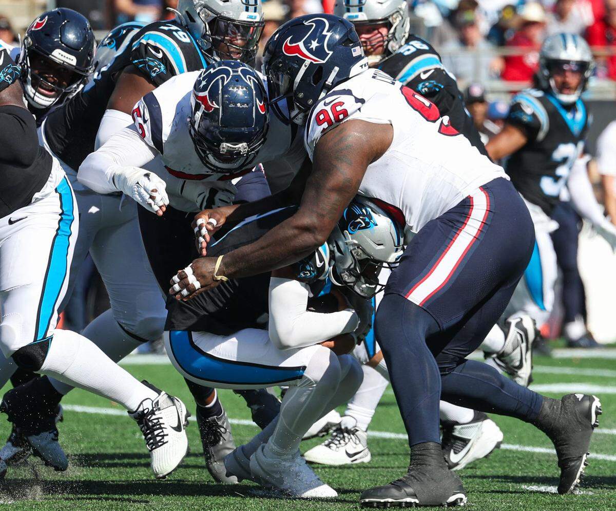 Carolina Panthers quarterback Bryce Young, second from right, hunches down as he is tackled by Houston Texans defensive tackle Maliek Collins during the game at Bank of America Stadium on Sunday, October 29, 2023.