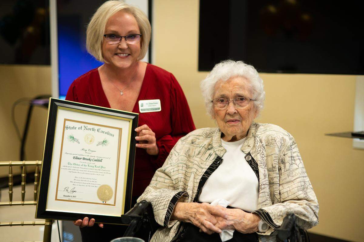 Elinor Caddell, UNC Charlotte professor emerita of nursing, left, was presented with the Order of the Long Leaf Pine, one of North Carolina’s highest honors, during her 100-year birthday celebration Monday amid colleagues and former students. Dena Evans, director of the School of Nursing, stands next to Caddell.