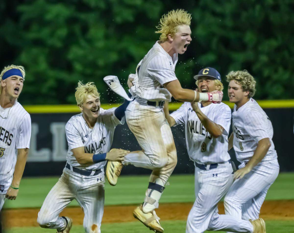 Cuthbertson players explode off the dugout bench, celebrating a clutch hit and final run in a regional semifinal win over West Forsyth in the NCHSAA 4A playoffs at Cuthbertson high school in Waxhaw, NC on May 16th, 2025
