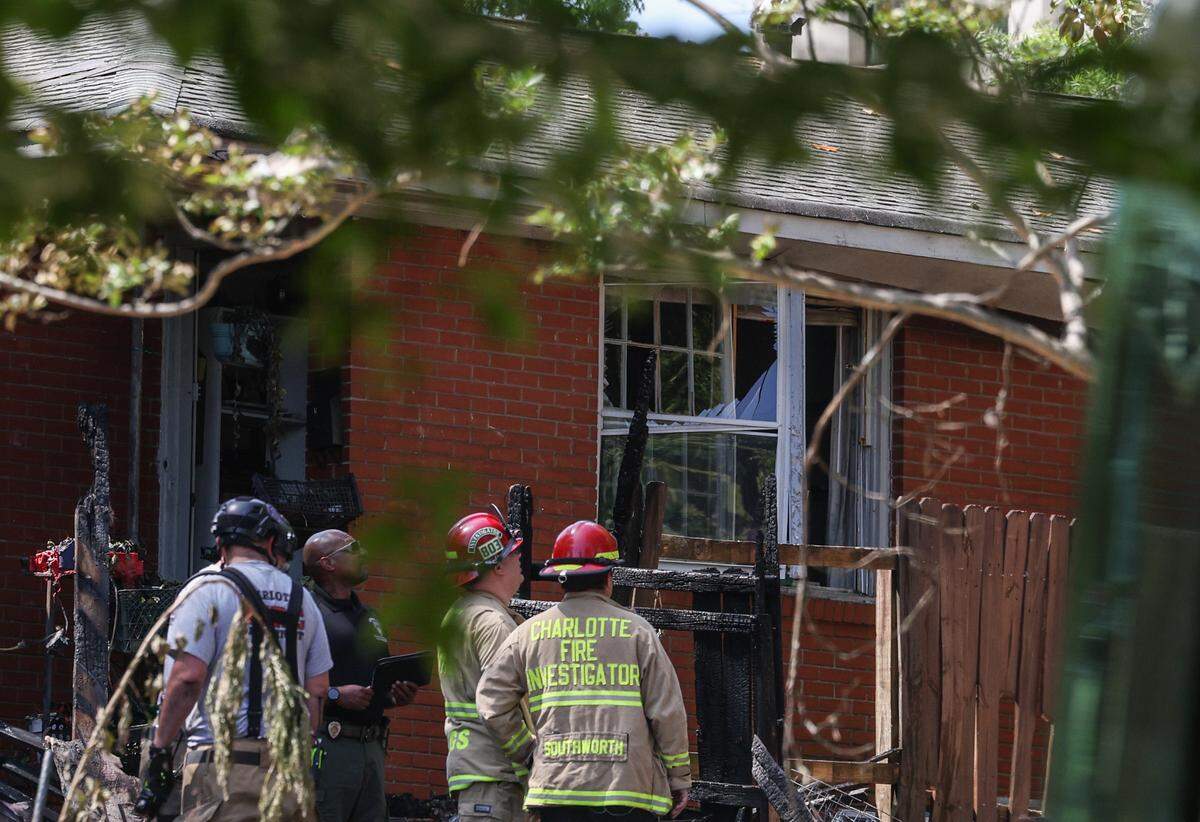Charlotte Fire Department officials work at the site of a house fire near Freedom Park after an explosion was reported early morning in Charlotte, NC on Friday, May 2, 2025.
