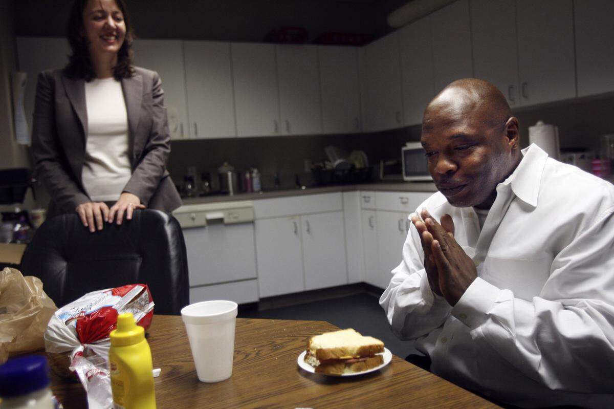 “It’s been too long,” said Glen Edward Chapman as he savors the first bite of his first meal as a free man, a bologna sandwich that he requested. He was joined by his attorney, Jessica Leaven, left, in the kitchen of the Academy of Trial Lawyers after being released from Central Prison.
