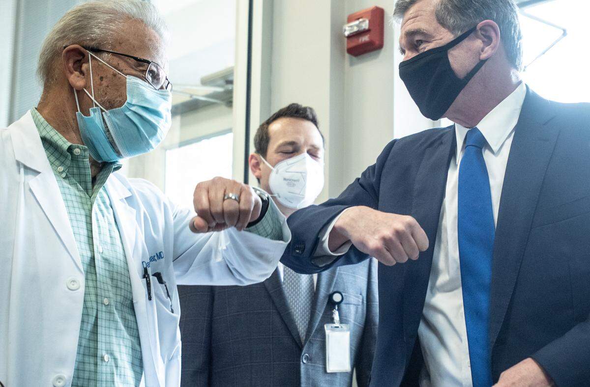 Gov. Roy Cooper (right) greets Dr. David Locklear at Gaston Medical Partners in Gastonia, NC, on Wednesday, March 31, 2021.